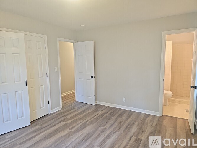 A room with white doors and a wooden floor.
