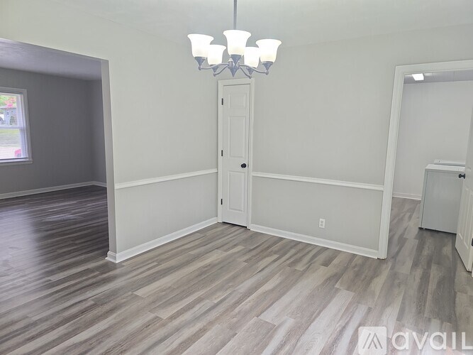 A room with a wooden floor and a white door.