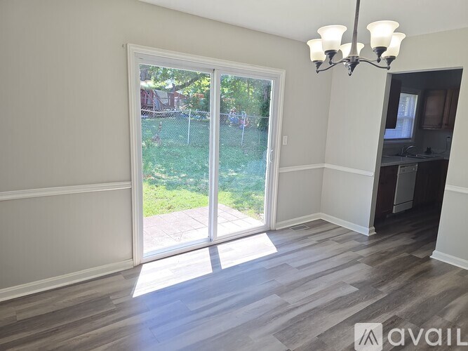 A room with a sliding glass door leading to a backyard.