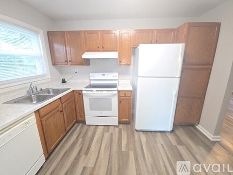 A kitchen with wooden cabinets and a white fridge.