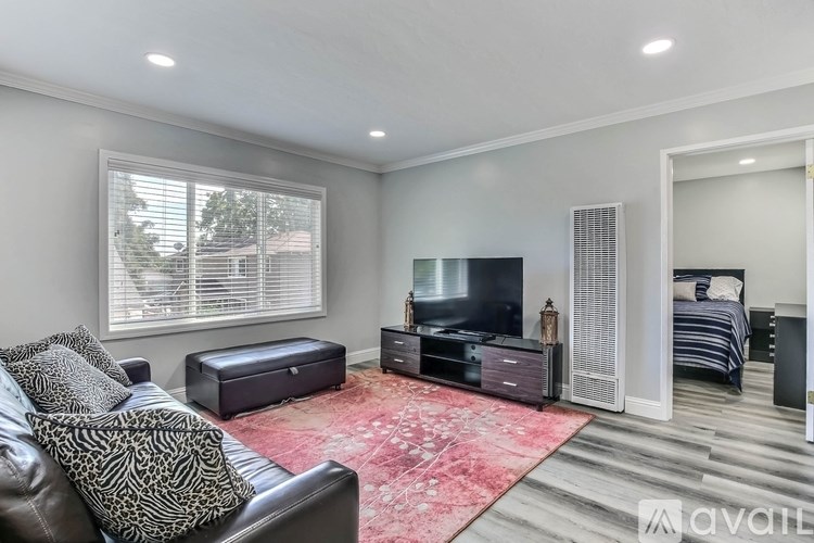 A living room with a leather couch and a television.