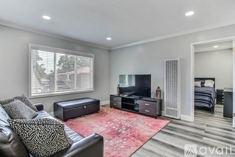 A living room with a leather couch and a television.