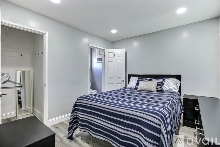 A bedroom with a bed, nightstand, and a wardrobe.