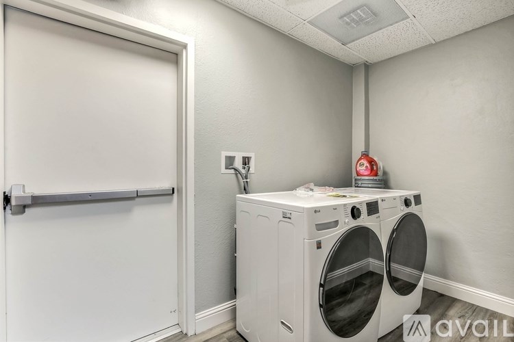 A white door is open to a room with a washer and dryer.