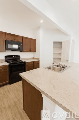 A kitchen with wooden cabinets and a black stove top oven.