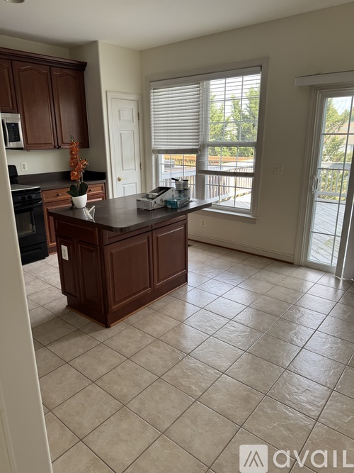 A kitchen with brown cabinets and a black countertop.