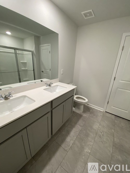 A bathroom with a toilet, sink, and mirror.