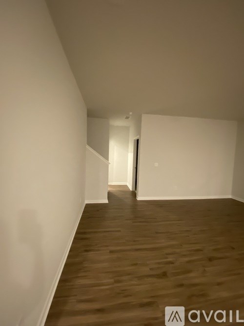 A long hallway with wooden floors and white walls.