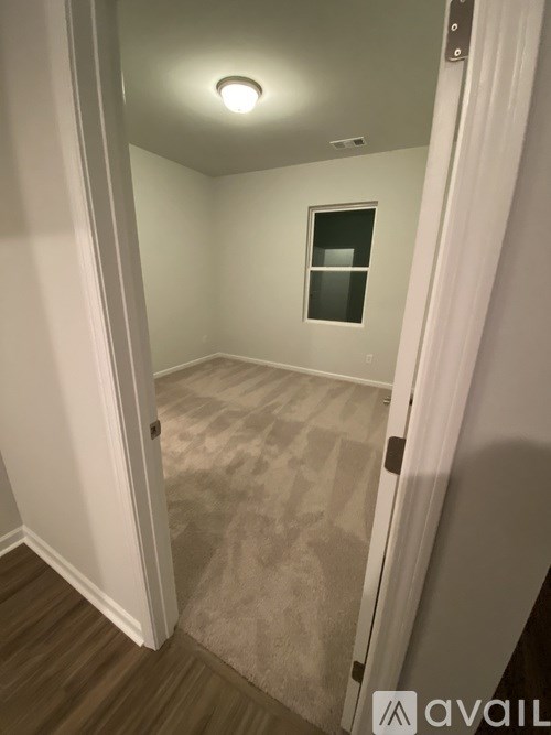 A room with a carpeted floor and a small window.