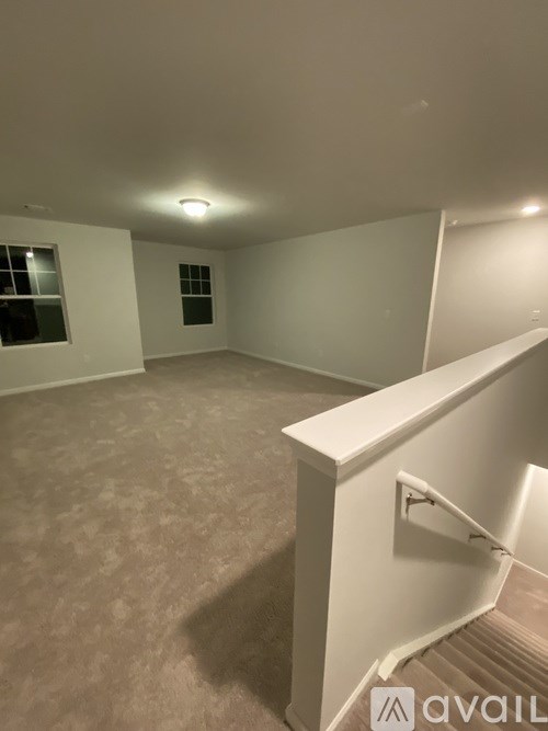 A room with a carpeted floor and a window.