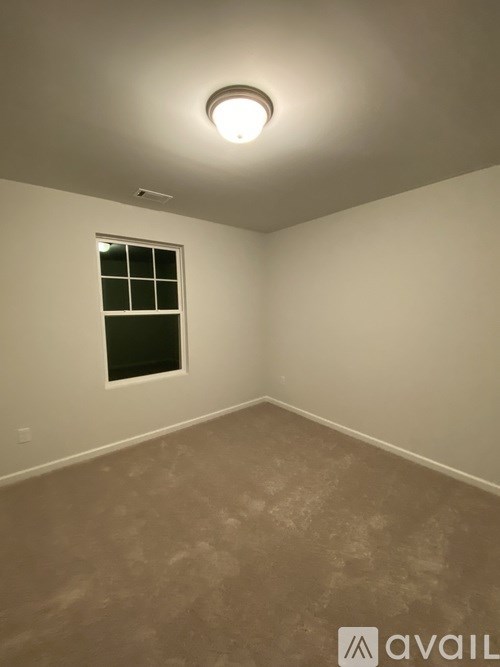 A room with a window and a light on the ceiling.