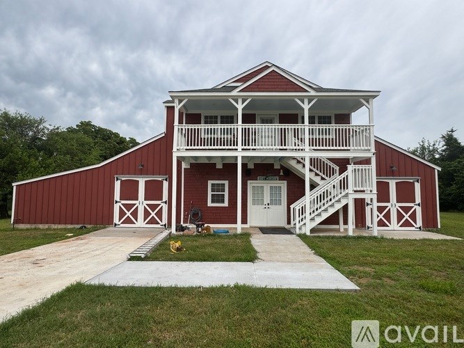 A red barn with white trim and a white porch.