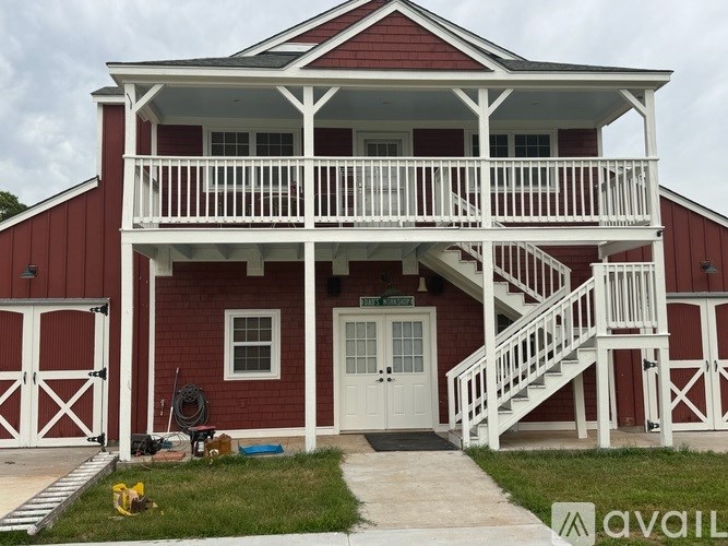 A red house with white railings and a white door.