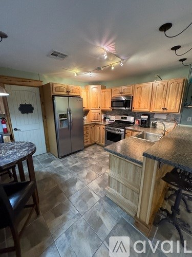 A kitchen with wooden cabinets and a granite countertop.