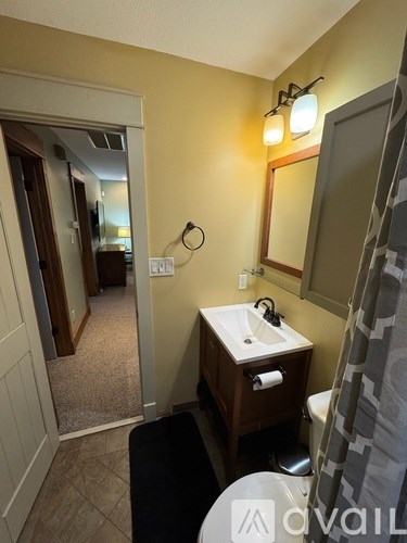 A bathroom with a sink, mirror, and toilet.