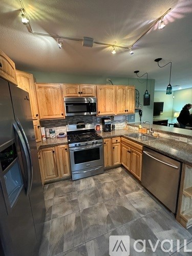 A kitchen with wooden cabinets and a tile floor.