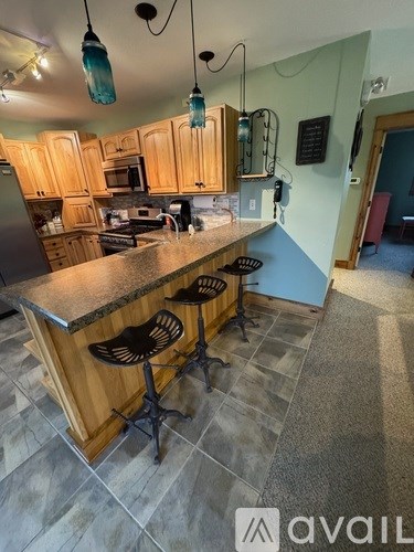 A kitchen with a bar stool in front of the island.
