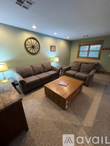A living room with two couches, a coffee table, and a rug.