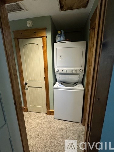 A white washing machine sits in a small laundry room.
