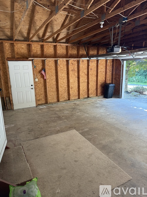 A room under construction with a white door and a flag hanging on the wall.