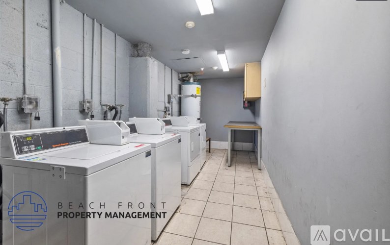 A clean, empty industrial kitchen with a logo for Beach Front Property Management on the bottom left.