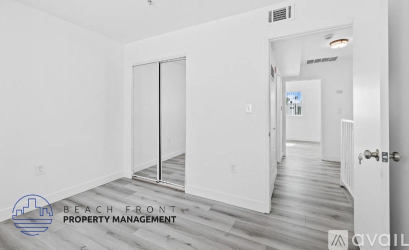 A room with a white door and a logo that says "Beach Front Property Management".