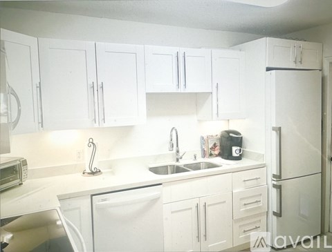 A kitchen with white cabinets and appliances.