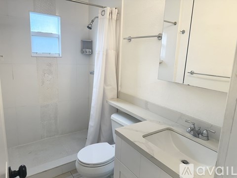 A white toilet is next to a sink in a bathroom.