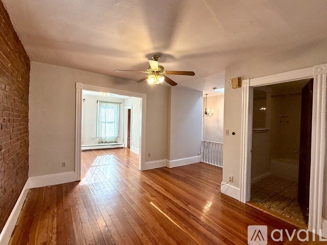 A room with wooden floors and a ceiling fan.