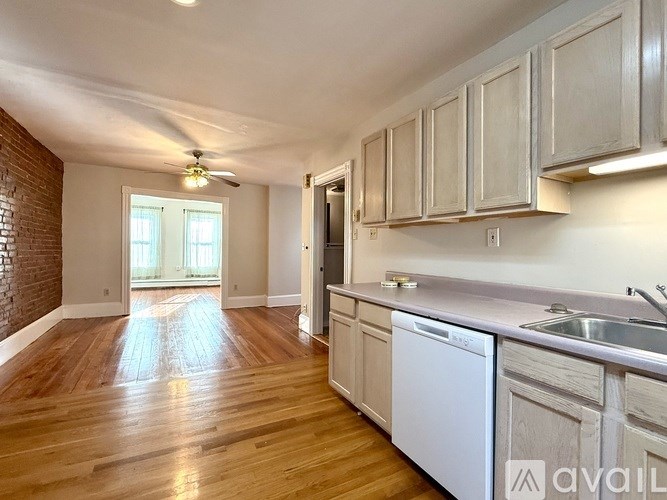 A kitchen with wooden floors and white appliances.