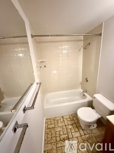 A white bathroom with a tub, toilet and sink.