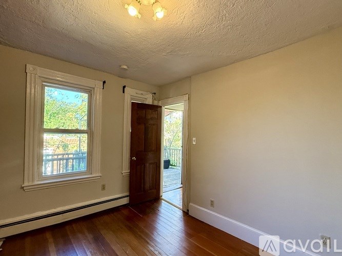 A room with a wooden floor and a brick wall.