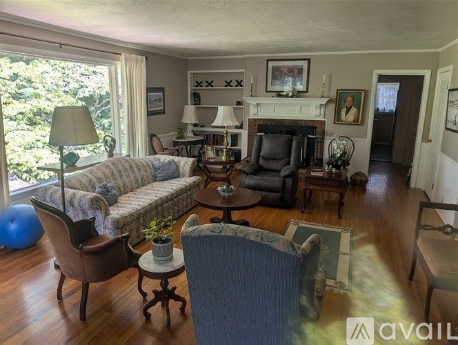 A living room with a sofa, chair, and fireplace.