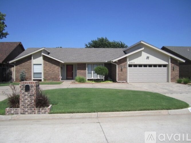 A house with a brick facade and a stone pillar in front.
