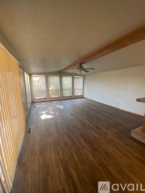 A room with wooden flooring and a ceiling fan.
