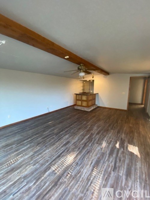 A room with wooden flooring and a ceiling fan.