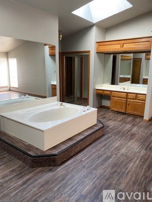 A bathroom with a large tub and wooden cabinets.