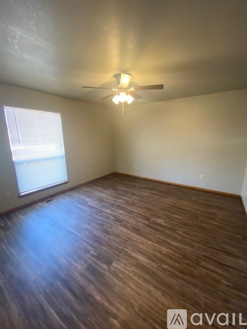 A room with wooden flooring and a ceiling fan.