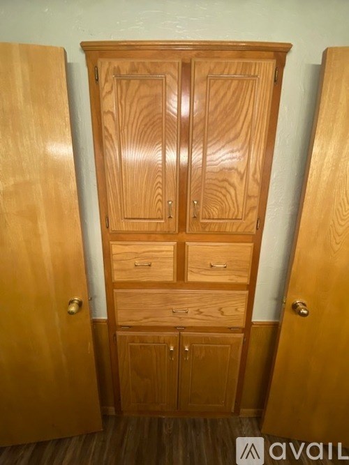 A wooden cabinet with two doors and two drawers is open.
