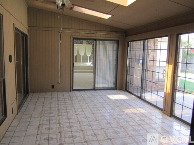 A room with a sliding glass door and a ceiling fan.