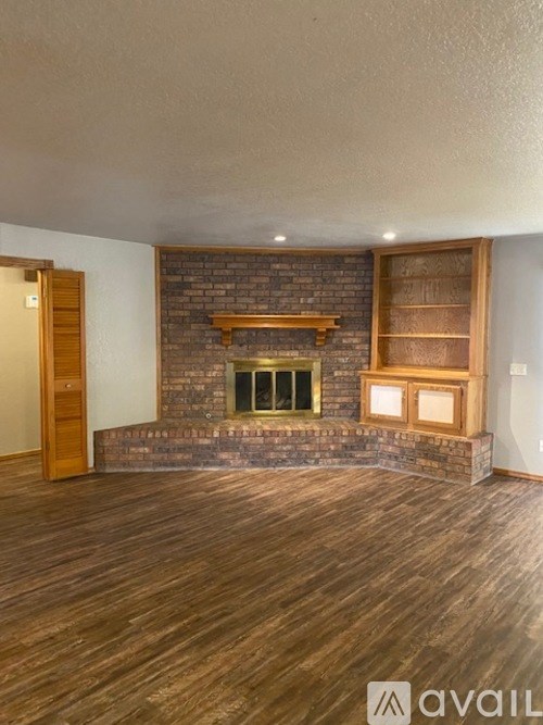 A room with a fireplace and wooden floors.