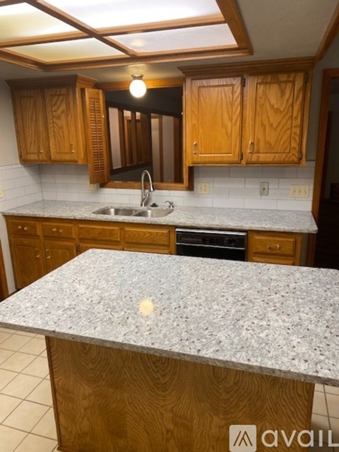 A kitchen with wooden cabinets and a granite countertop.
