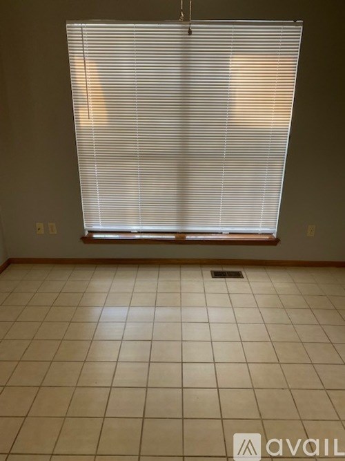 A room with a window covered in blinds.