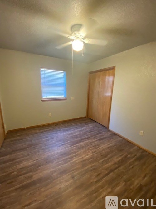 A room with wooden flooring and a ceiling fan.