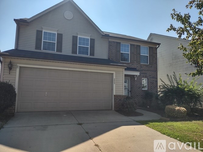 A two-story house with a garage and a driveway.