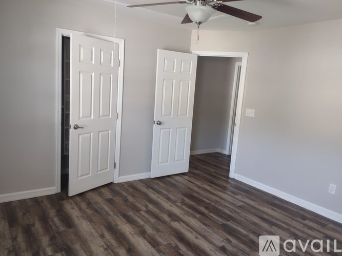 A room with two doors and a ceiling fan.