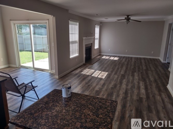 A room with a ceiling fan and a table with a chair.