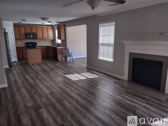 A living room with a fireplace and a dining area with a table and chairs.