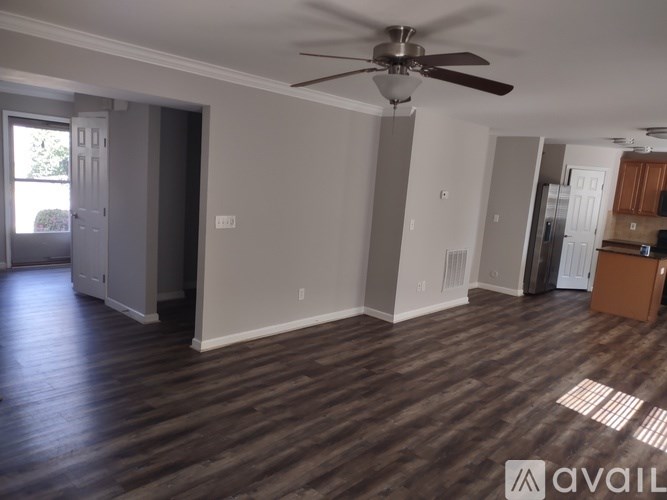 A room with a ceiling fan and wooden flooring.