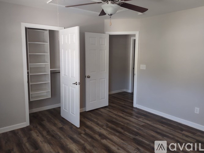 A room with a ceiling fan and two doors, one of which is open.